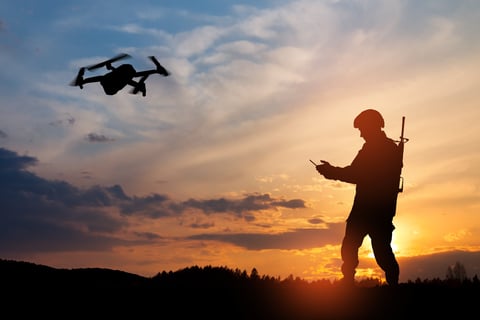 Drone operator silhouette against dramatic sunset backdrop