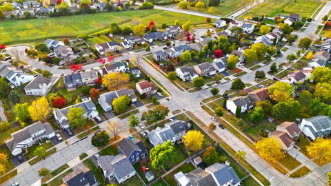 Aerial view of a suburban neighborhood in autumn with colorful trees and neatly arranged houses