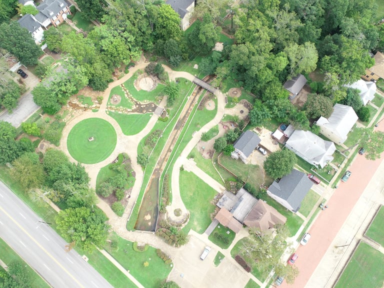 Aerial view of a residential neighborhood with parks, green spaces, tree-lined streets, and residential buildings
