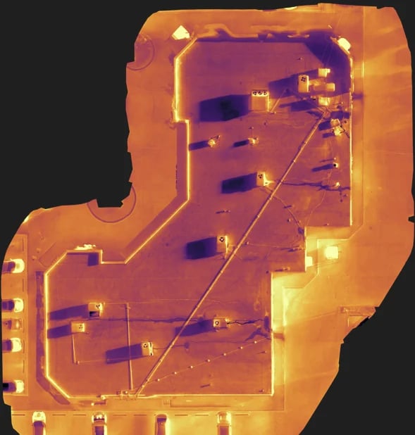 Thermal image of a circuit board showing heat distribution with orange and yellow indicating warm areas and components